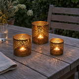 Photophores Noor allumés sur table extérieure en bois – ambiance nocturne